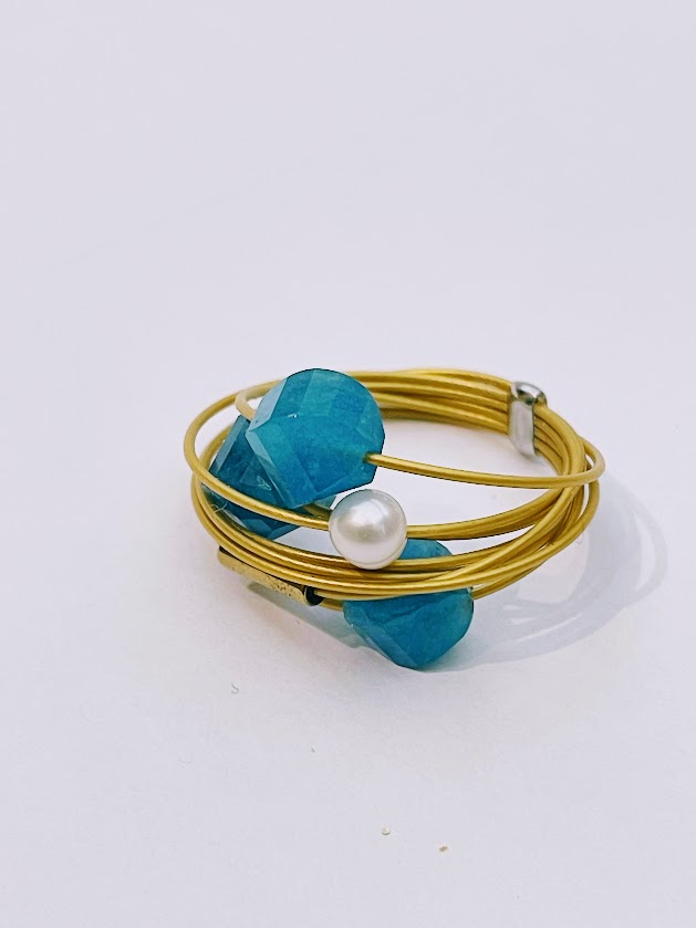 Anello a filo dorato con doppi turchesi e Perla