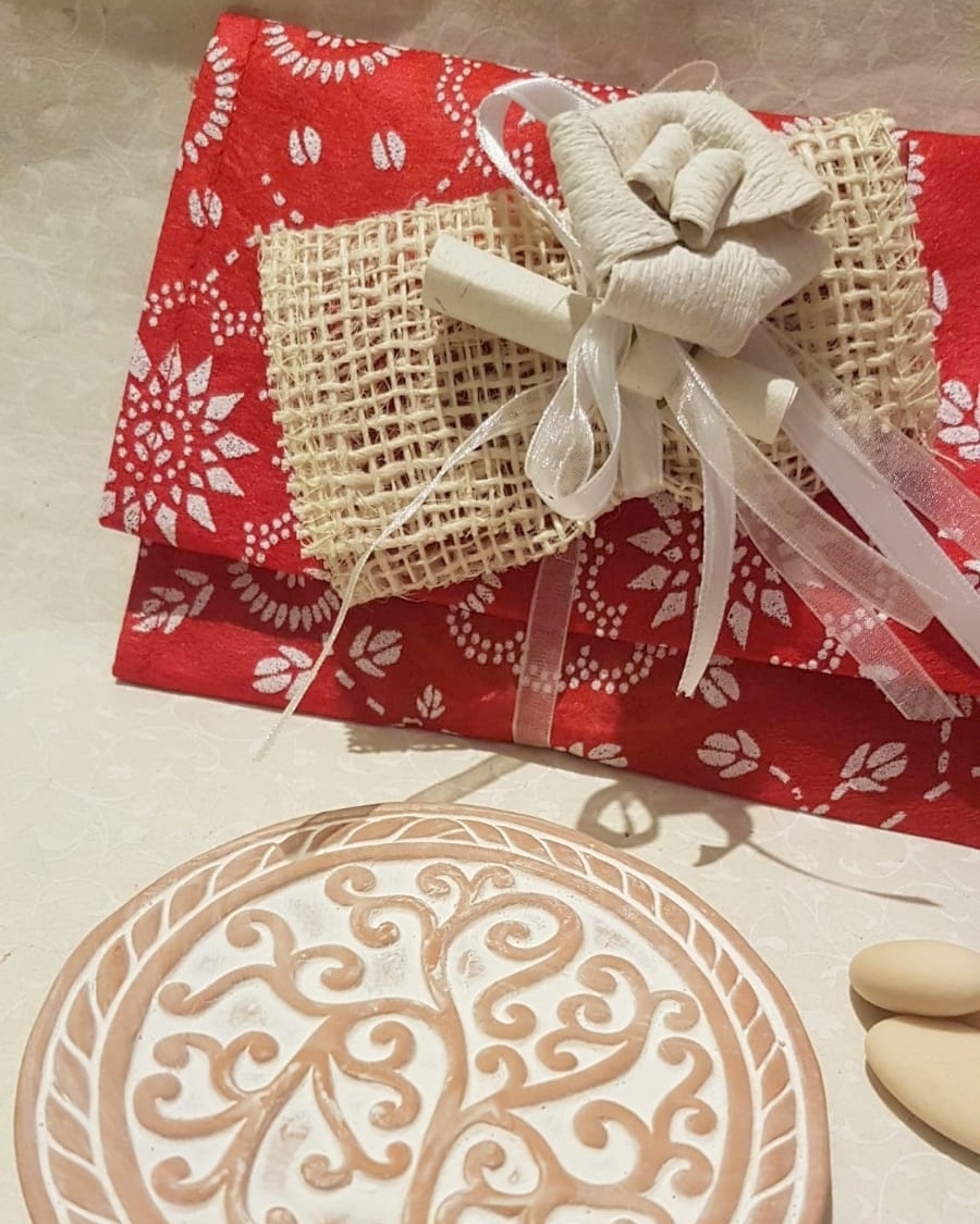 Bomboniera sottopentola con albero della vita in terracotta, con sacchetto rosso in carta seta e portaconfetti con fiore