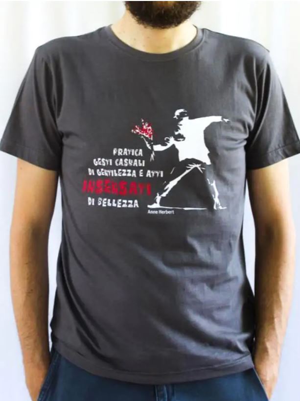 Maglietta unisex grigia a manica corta, con la frase “Pratica gesti casuali di gentilezza e atti insensati di bellezza”  
