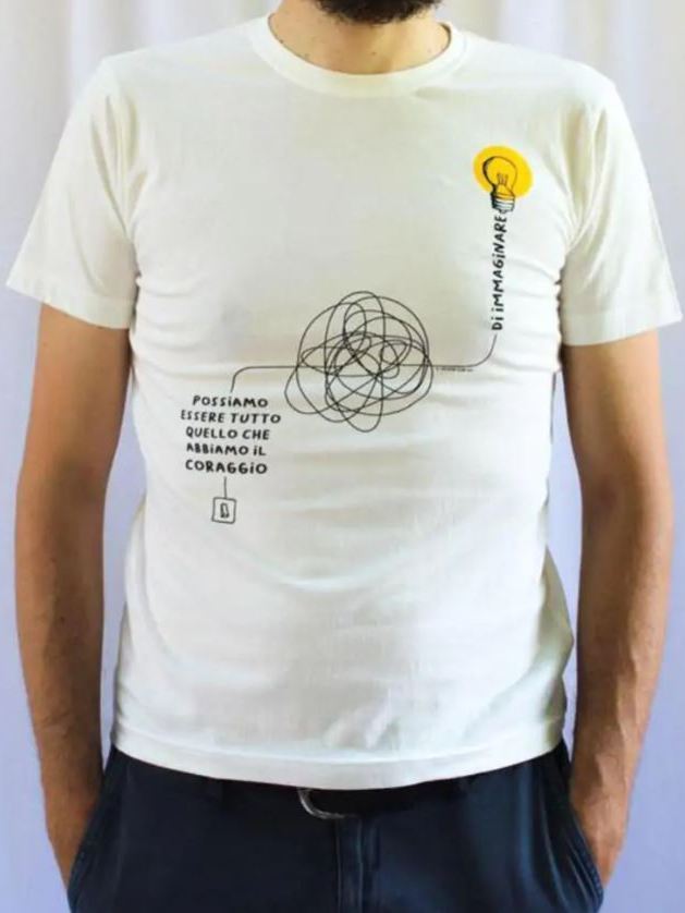 Maglietta bianca a manica corta con il disegno di un circuito elettrico e la frase "Possiamo essere tutto quello che abbiamo il coraggio di immaginare"