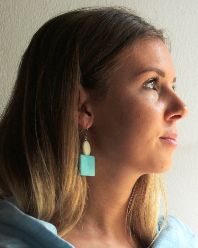 Orecchini in tagua integliata pop azzurri indossati
