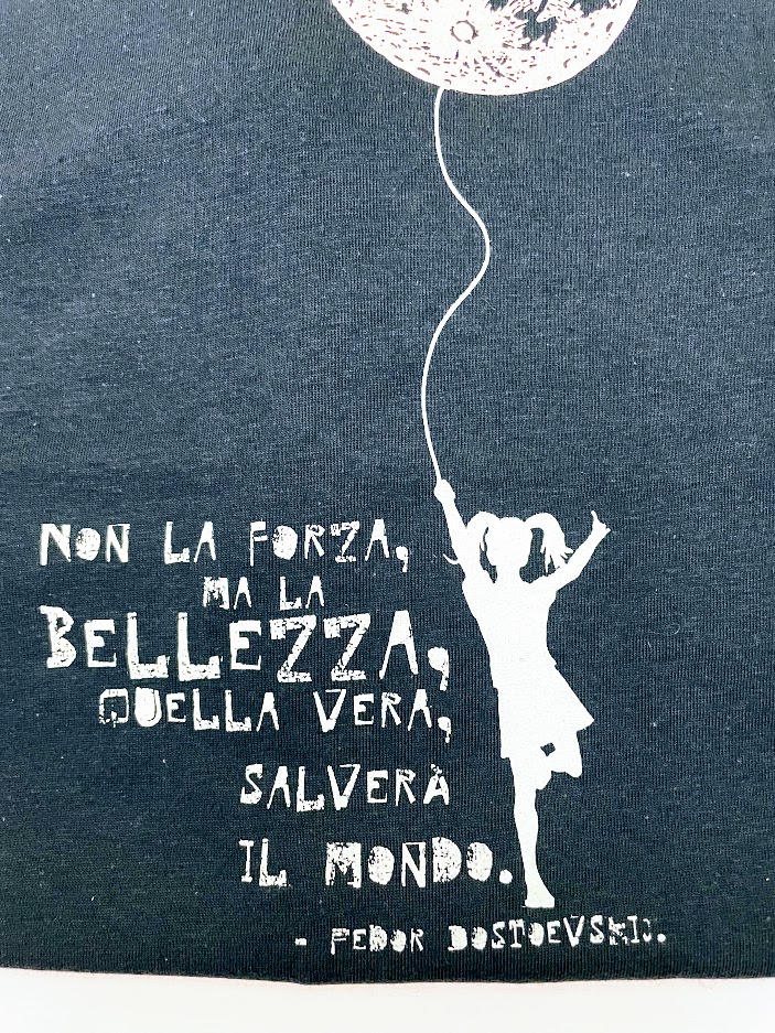 Maglietta unisex a manica corta blu, con la frase "non la forza ma la belleza salverà il mondo"